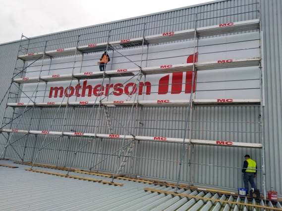 Montage eines 15 x 4 Meter großen Fassadenschildes für das Unternehmen Motherson an einer Industriehalle in Deutschland durch Rechinger Werbetechnik GmbH – Spezialist für professionelle Außenwerbung und großformatige Werbeschilder aus hochwertigem Material.